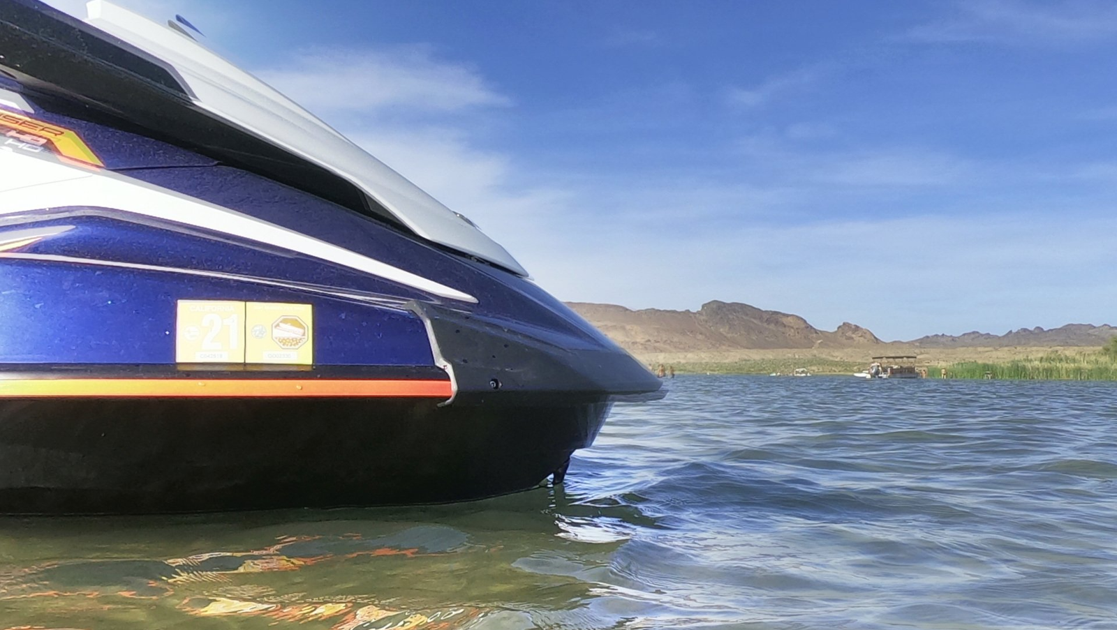 Bow of a blue jet ski in shallow water